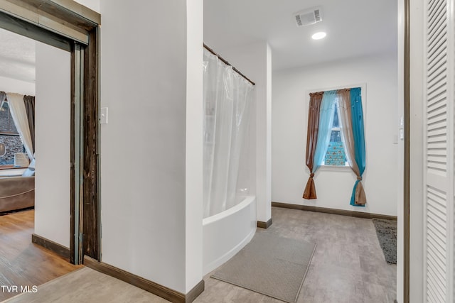 bathroom featuring wood-type flooring and shower / tub combo