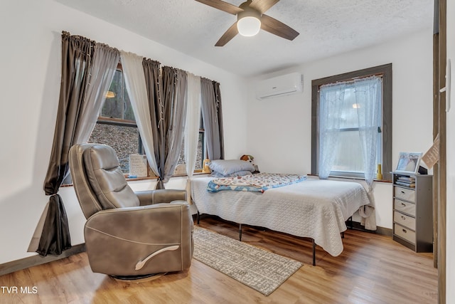 552 Jerrys Br, Clintwood, VA 24228 - bedroom with a wall mounted air conditioner, multiple windows, wood finished floors, and a textured ceiling