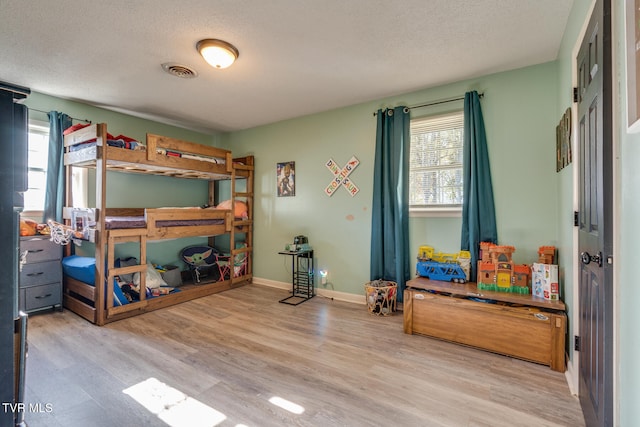 bedroom with wood-type flooring and a textured ceiling