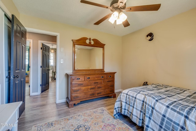 bedroom featuring a textured ceiling, light hardwood / wood-style flooring, and ceiling fan