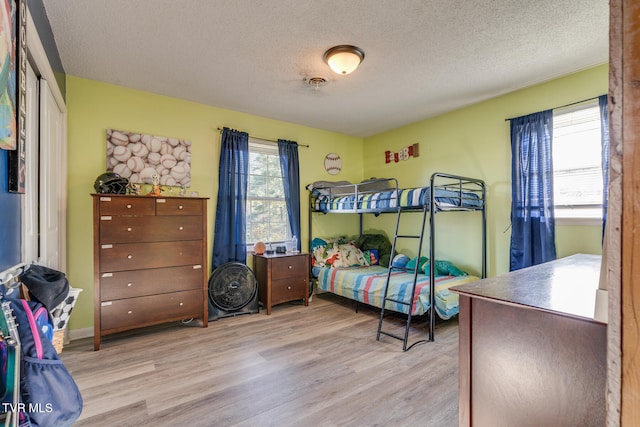 bedroom featuring a textured ceiling and light hardwood / wood-style flooring