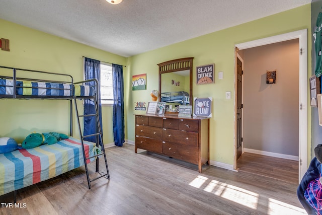 bedroom featuring light hardwood / wood-style flooring and a textured ceiling