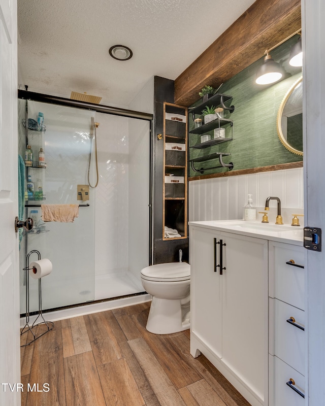 bathroom featuring hardwood / wood-style floors, walk in shower, a textured ceiling, and toilet