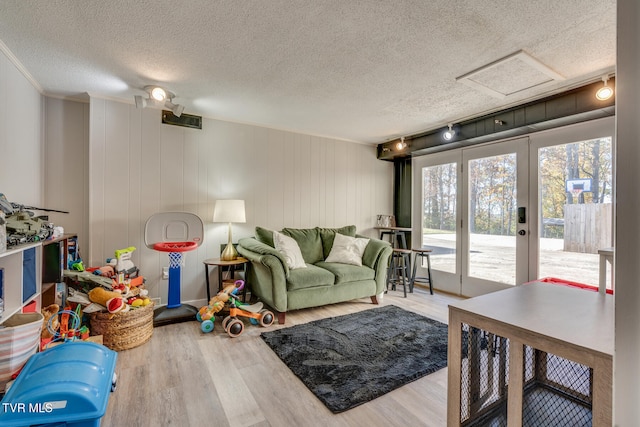 living room with wooden walls, a textured ceiling, and hardwood / wood-style flooring