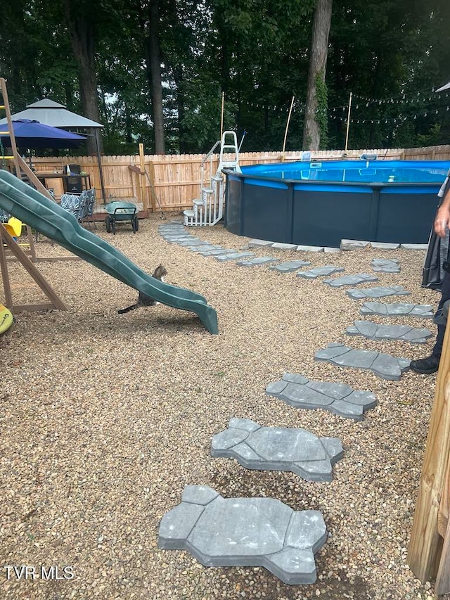 view of swimming pool featuring a playground