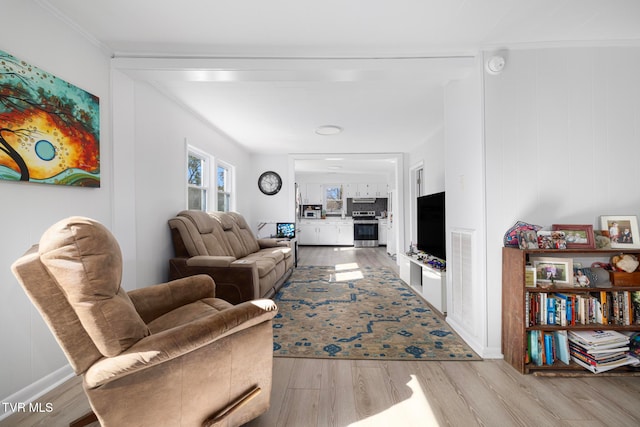 living room with light hardwood / wood-style flooring and crown molding