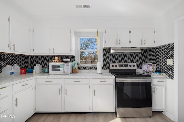 kitchen featuring white cabinetry, light wood-type flooring, wall chimney range hood, and stainless steel range with electric cooktop