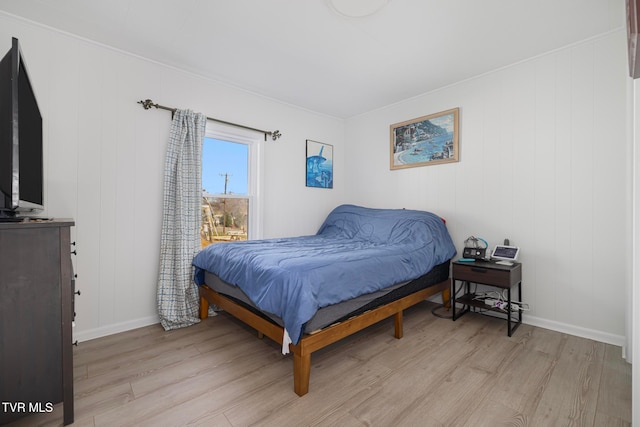 bedroom featuring wooden walls and light hardwood / wood-style floors