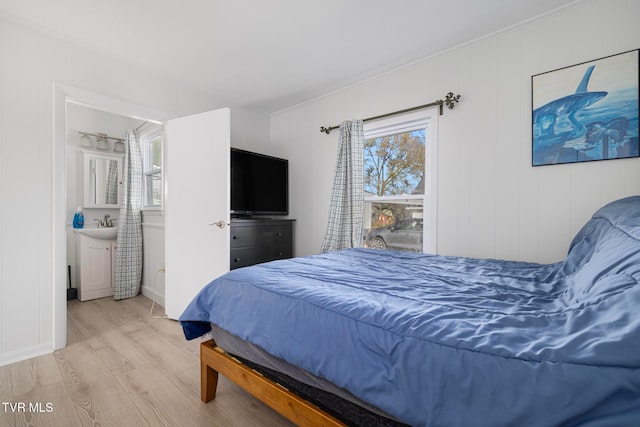 bedroom featuring ornamental molding and light hardwood / wood-style flooring