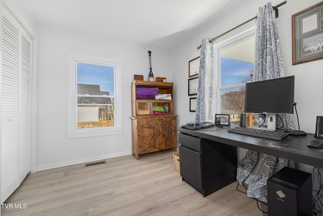 office with light hardwood / wood-style flooring and crown molding