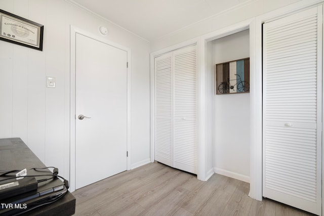 hallway featuring light hardwood / wood-style floors and ornamental molding