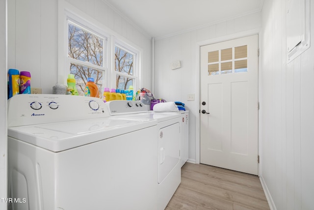 laundry area with wooden walls, light wood-type flooring, separate washer and dryer, and crown molding