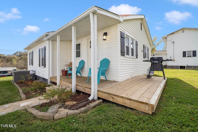 back of house with cooling unit and a yard