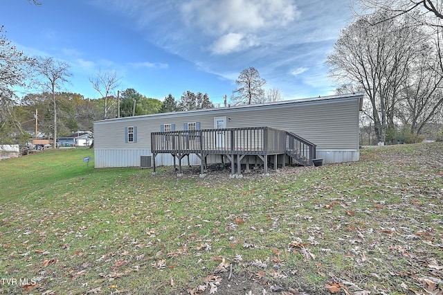 rear view of property with central AC unit, a lawn, and a wooden deck