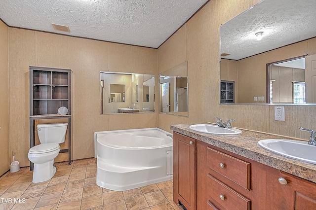 bathroom with a bathtub, tile patterned floors, vanity, a textured ceiling, and toilet