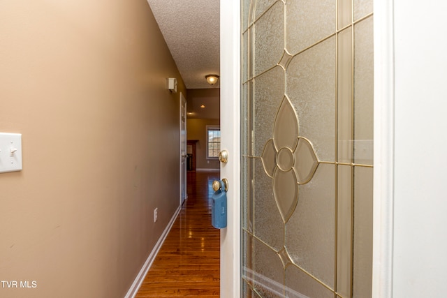 hallway featuring a textured ceiling and hardwood / wood-style flooring