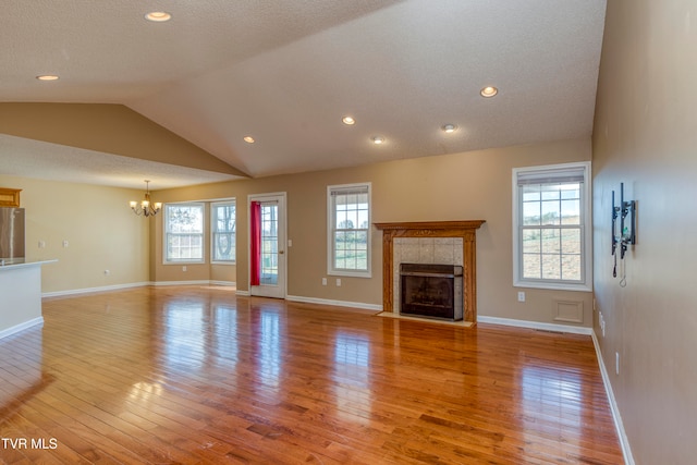 unfurnished living room with light hardwood / wood-style floors, a wealth of natural light, and lofted ceiling