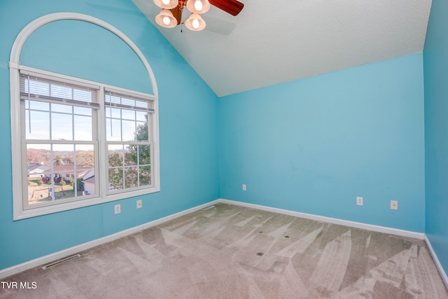 carpeted empty room featuring a textured ceiling, ceiling fan, and vaulted ceiling