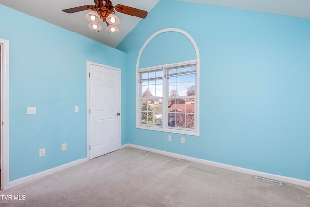 carpeted spare room featuring high vaulted ceiling and ceiling fan