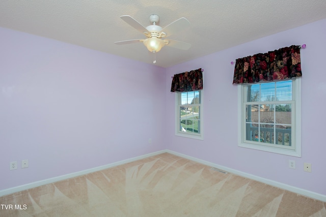 spare room with carpet, ceiling fan, and a textured ceiling