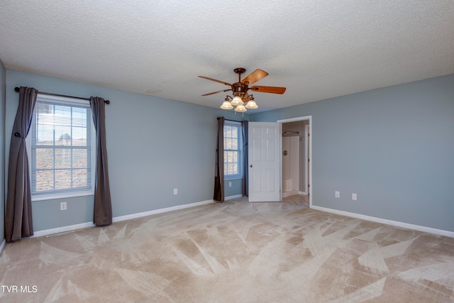 carpeted spare room featuring ceiling fan and a textured ceiling