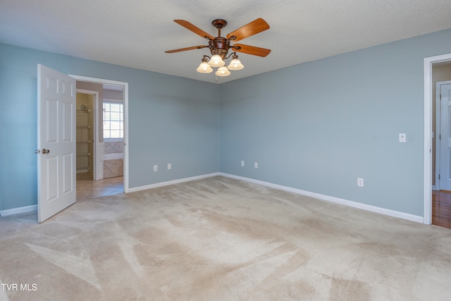 carpeted spare room with ceiling fan and a textured ceiling