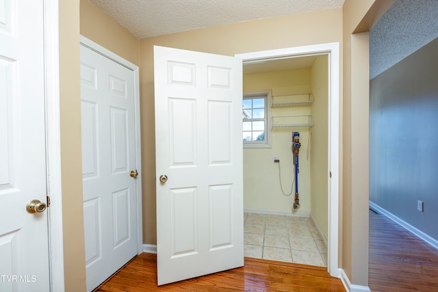 corridor featuring wood-type flooring and a textured ceiling