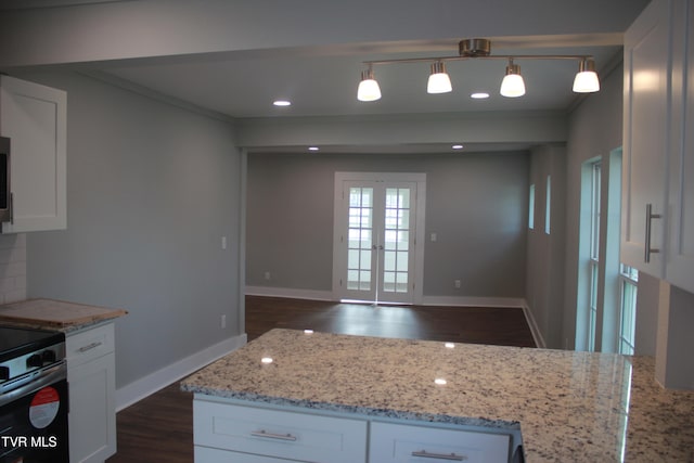 kitchen with dark wood-type flooring, french doors, hanging light fixtures, light stone counters, and white cabinetry