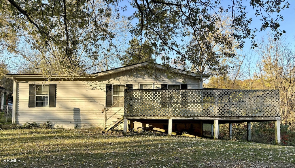 view of property exterior featuring a lawn and a wooden deck