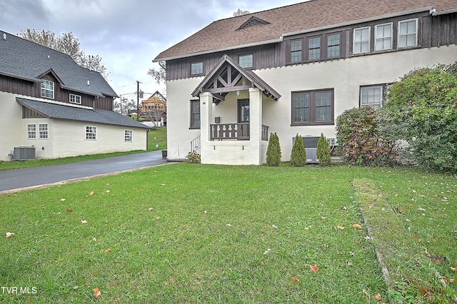 view of front of house with a front lawn and cooling unit