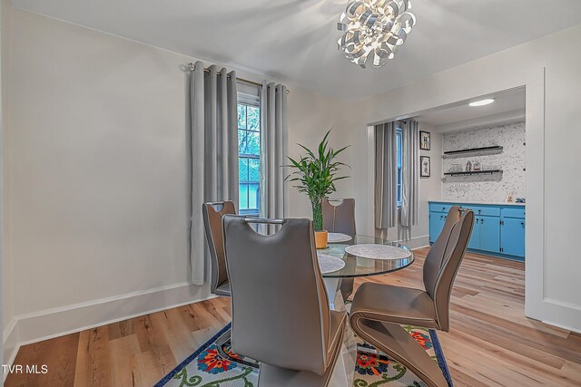 dining area featuring light wood-type flooring and an inviting chandelier