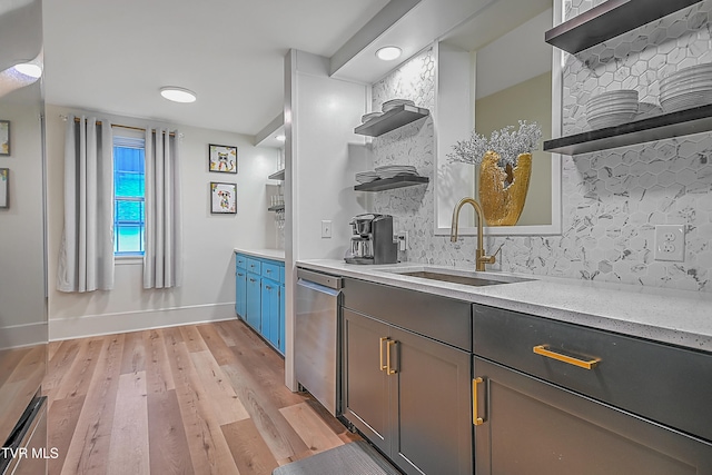 kitchen with dishwasher, sink, and light hardwood / wood-style flooring