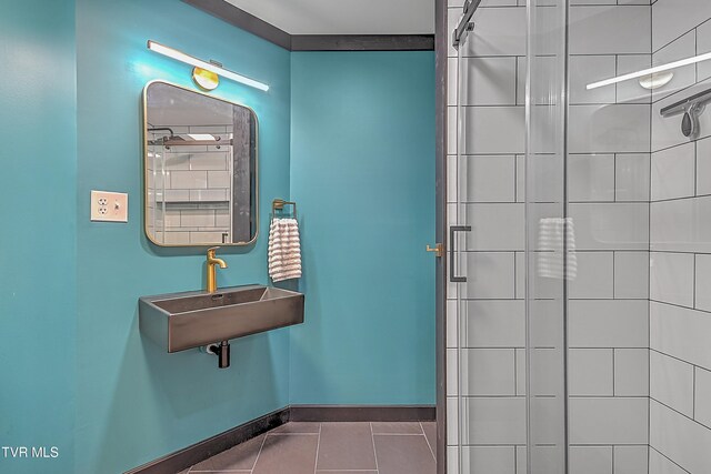 bathroom featuring tile patterned flooring, sink, and tiled shower