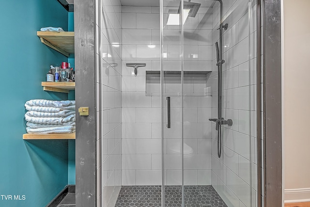 bathroom featuring a shower with door