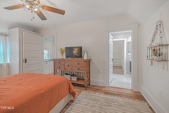 bedroom with ceiling fan, light hardwood / wood-style flooring, and lofted ceiling