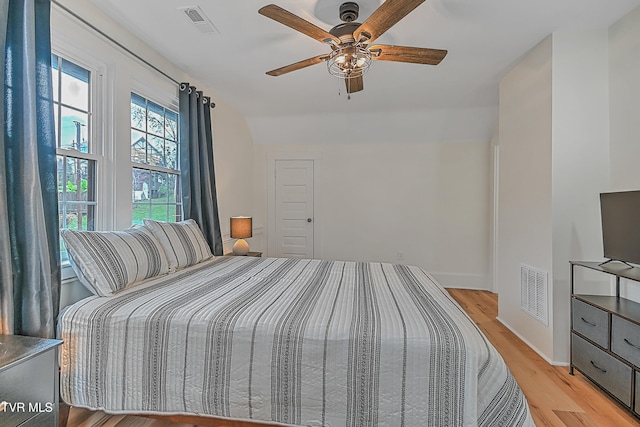 bedroom with light wood-type flooring, ceiling fan, and lofted ceiling