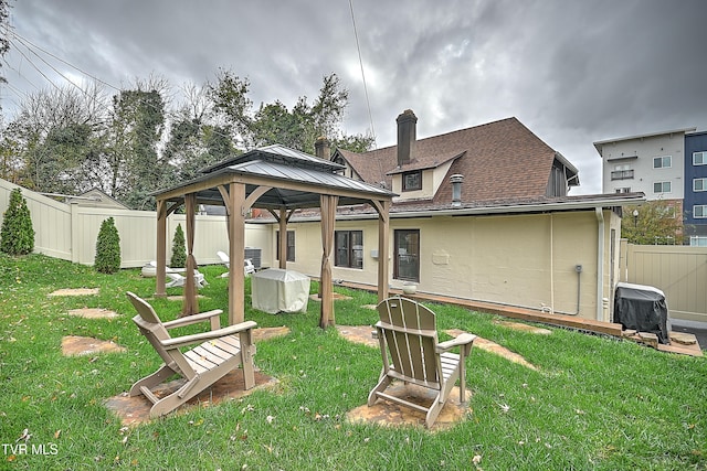 back of house with a gazebo and a yard