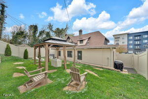 back of house with a gazebo and a lawn