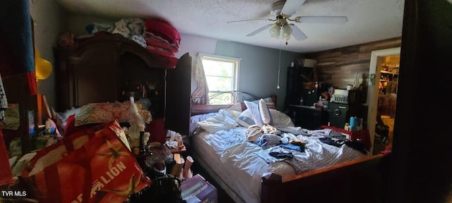 bedroom with ceiling fan and a textured ceiling