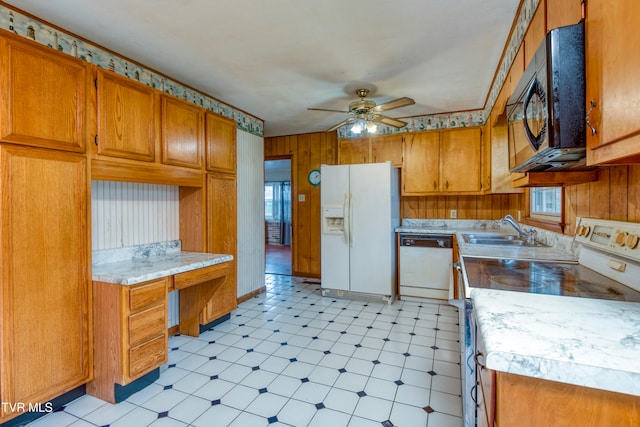 kitchen with white appliances, ceiling fan, wooden walls, and a wealth of natural light