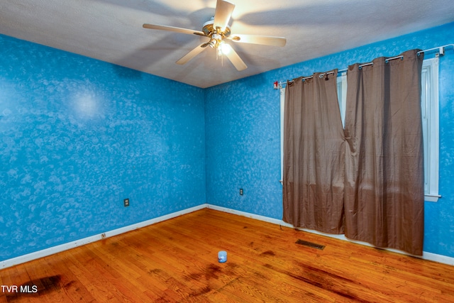 unfurnished room with hardwood / wood-style flooring, ceiling fan, and a textured ceiling