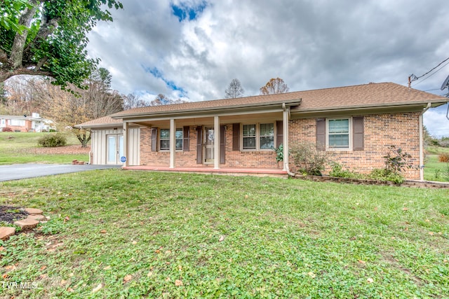 ranch-style home with a front lawn, a garage, and a porch