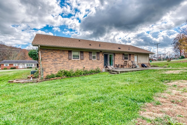 back of property with a patio area and a lawn