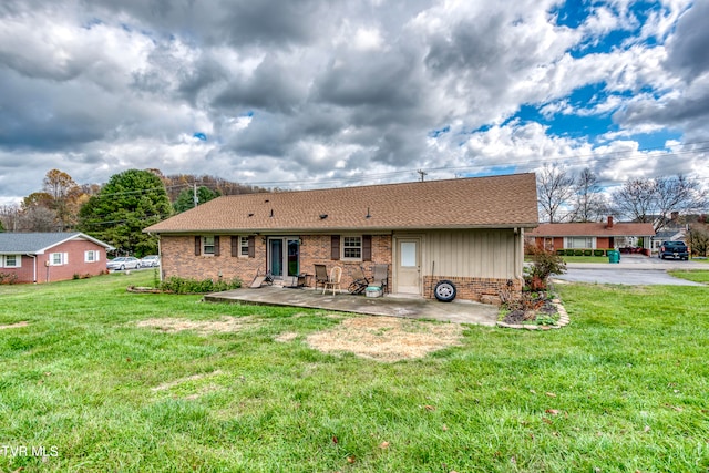 back of house with a patio and a lawn