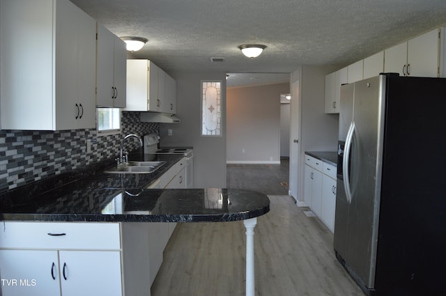 kitchen featuring light hardwood / wood-style floors, white cabinetry, sink, appliances with stainless steel finishes, and a textured ceiling