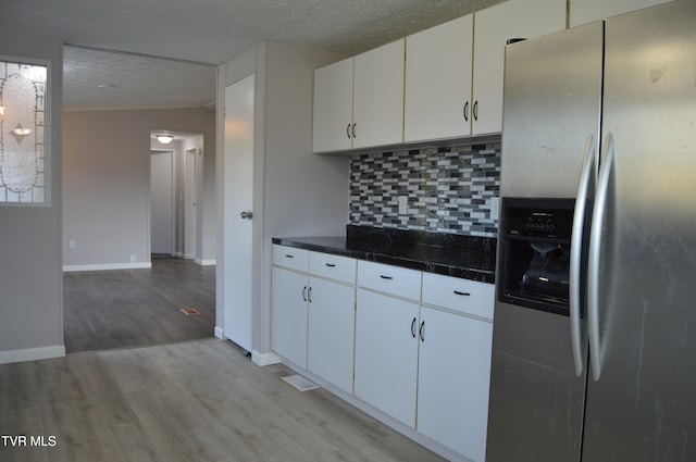 kitchen with a textured ceiling, stainless steel fridge with ice dispenser, light hardwood / wood-style floors, and white cabinets