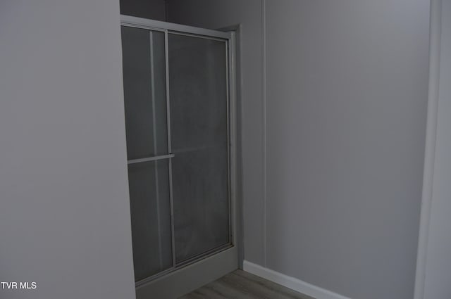 bathroom featuring hardwood / wood-style flooring and a shower with shower door