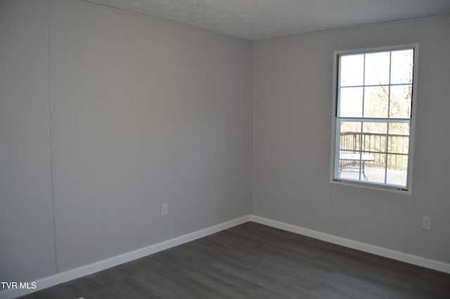 spare room with dark hardwood / wood-style flooring and a textured ceiling