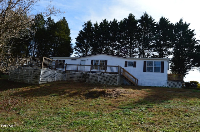 rear view of house with a wooden deck and a yard