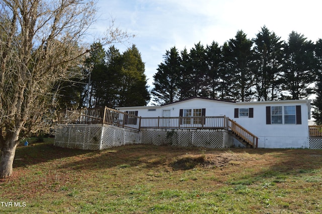 rear view of house featuring a deck and a yard